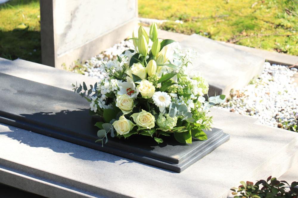 bouquet de fleurs blanches au pied d'une sépulture